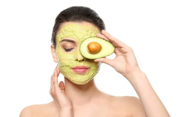 the perfect diy avocado face mask recipe for every skin type, Beautiful young woman with facial mask and fresh avocado on white background