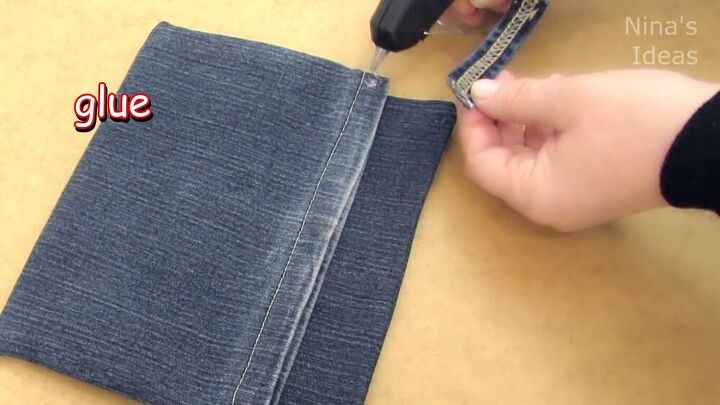 got an old pair of jeans turn them into a cute diy denim clutch, Gluing the belt loop onto the denim clutch