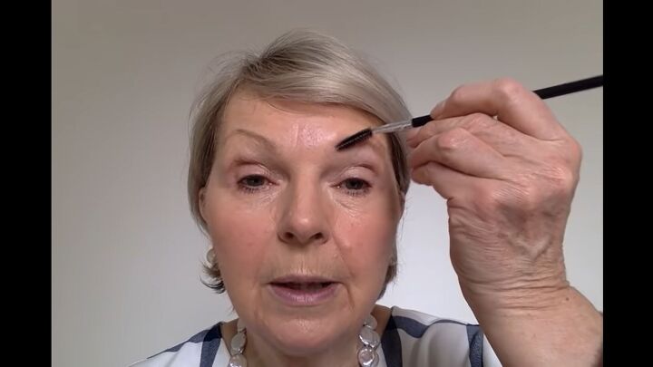 how to easily perfectly apply eye makeup for mature women, Using a spoolie brush to neaten eyebrows