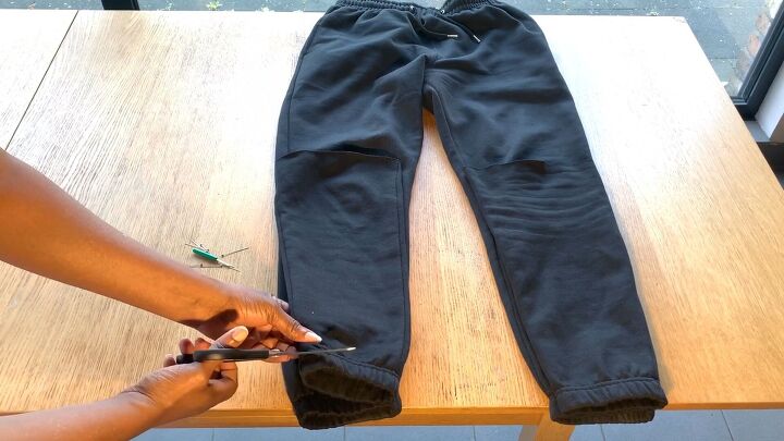 how to make trendy diy stacked pants out of 2 pairs of sweatpants, Cutting off the cuffs