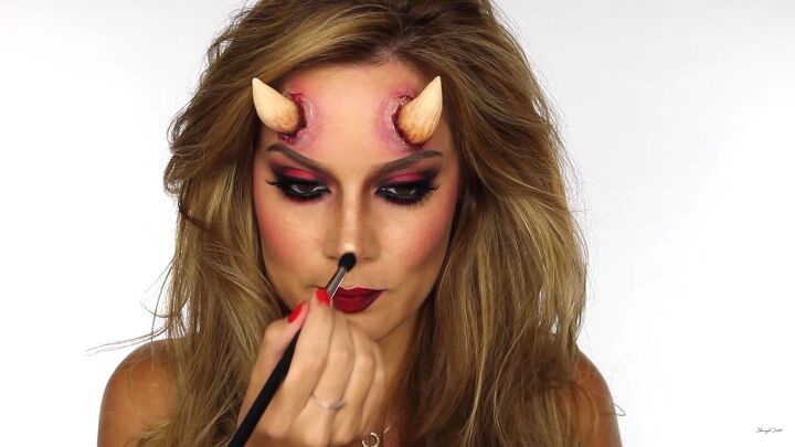 how to do sexy devil makeup for halloween complete with horns, Applying shimmer to the tip of the nose