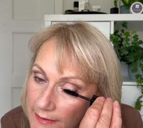 this warm autumn eye makeup for older eyes is perfect for fall, Applying black mascara to lashes