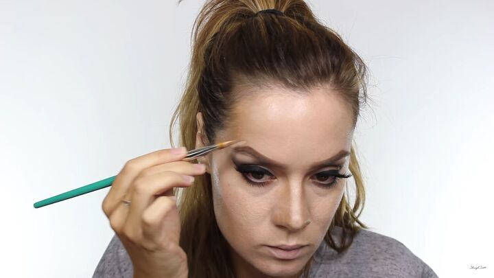 how to do amazing maleficent halloween makeup step by step, Applying highlighter above the eyebrows