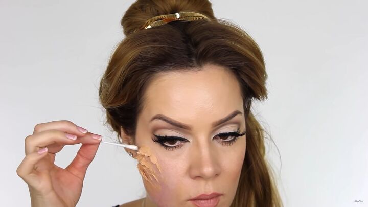 try this fun scary belle from beauty and the beast halloween makeup, Applying sealant to the wax with a cotton bud