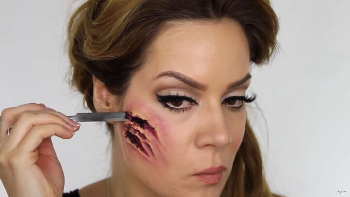 try this fun scary belle from beauty and the beast halloween makeup, Applying wound filler with a spatula