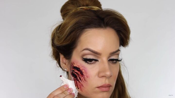 try this fun scary belle from beauty and the beast halloween makeup, Smearing the TV blood with a tissue