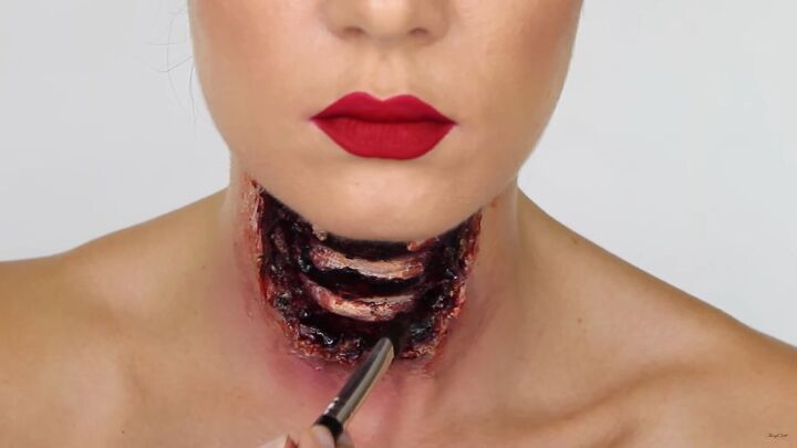 this gory ariel little mermaid makeup look is perfect for halloween, Applying liquid blood to the FX wound
