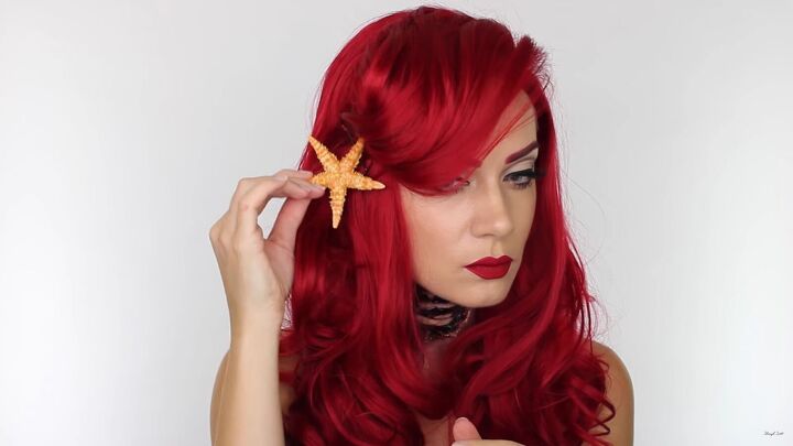 this gory ariel little mermaid makeup look is perfect for halloween, Placing the starfish on the Ariel wig
