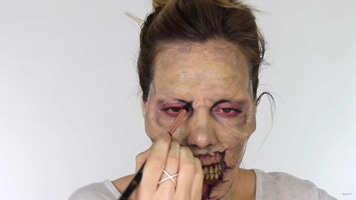 looking for a fun halloween look try this chilling zombie sfx makeup, Applying red and black around the eyes