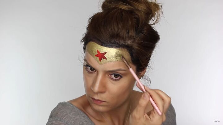 how to do effective comic book wonder woman makeup for halloween, Applying black and gold to the sides