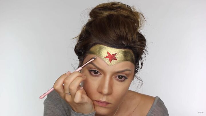 how to do effective comic book wonder woman makeup for halloween, Applying brown eyeshadow under the mask