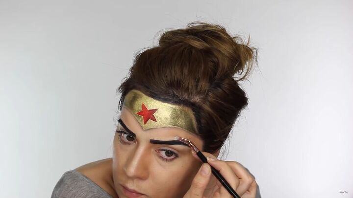 how to do effective comic book wonder woman makeup for halloween, Adding highlighter around the brows
