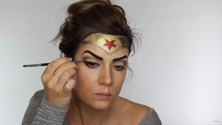 how to do effective comic book wonder woman makeup for halloween, Lining the eyes with a black cream liner