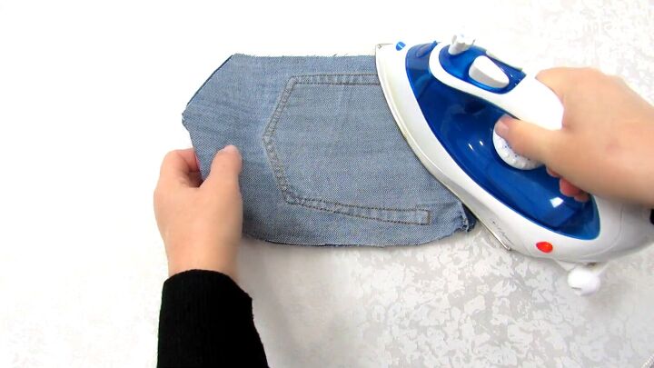 how to make a jean pocket purse with cute fringe detailing, Ironing the jeans to press the fold
