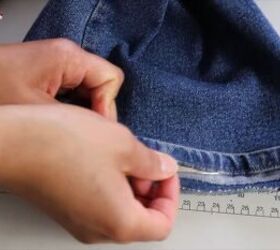 jeans too long here s how to hem flared jeans keep the original hem, Using a seam ripper to remove the stitching