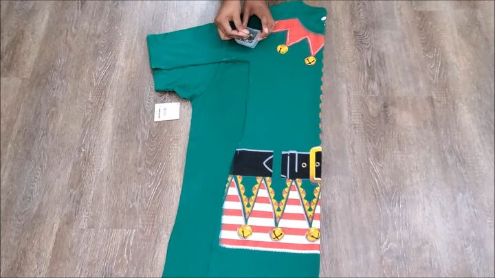 how to make an easy diy elf costume using a novelty christmas t shirt, Folding and cutting the fabric for symmetry