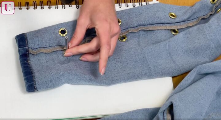 how to customize your jeans 3 different ways for a totally unique look, Hammering grommets into the jeans