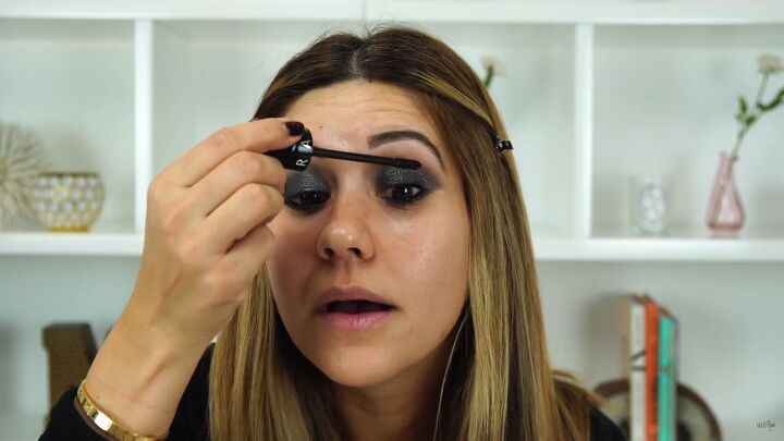 this sexy black glitter makeup look is perfect for holiday parties, Applying mascara to the upper lashes
