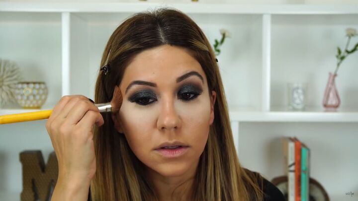 this sexy black glitter makeup look is perfect for holiday parties, Applying bronzer to the face
