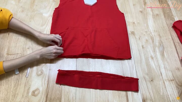 how to make a cute diy christmas dress out of an old red hoodie, Unpicking the pocket with a seam ripper