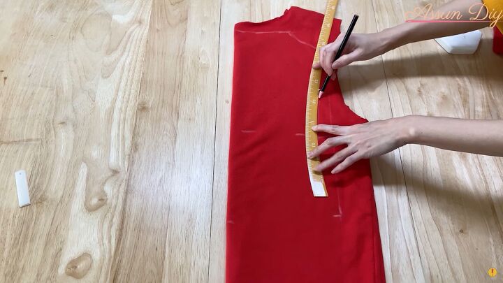 how to make a cute diy christmas dress out of an old red hoodie, Using a curved ruler to mark the bust