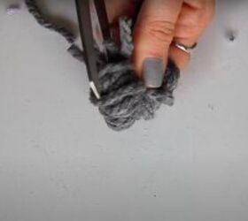 how to make an easy no sew diy sweater christmas stocking, Cutting the loops of the pompom open