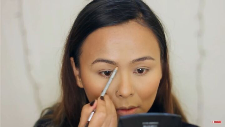 ring in the new year in style with this sultry new year s makeup look, Filling out eyebrows with a pencil