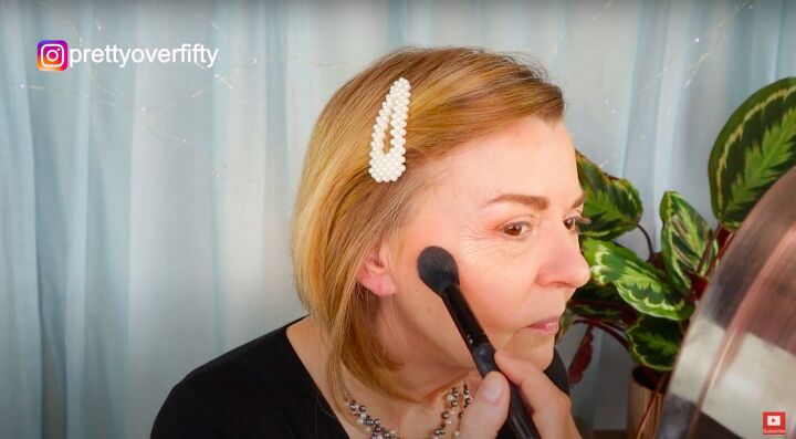 how to do a festive glam holiday makeup look over 50, Applying gold shimmer highlight
