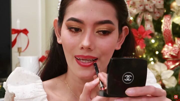 need some festive makeup inspo try this easy holiday makeup look, Applying red lip liner and lipstick