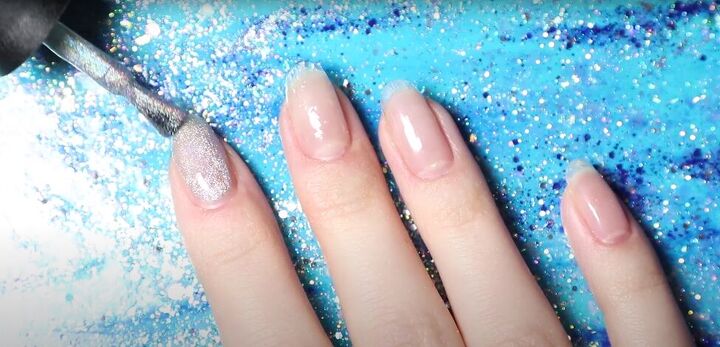 how to do easy blue silver nails with snowflakes for winter, Applying gel glitter nail polish to nails
