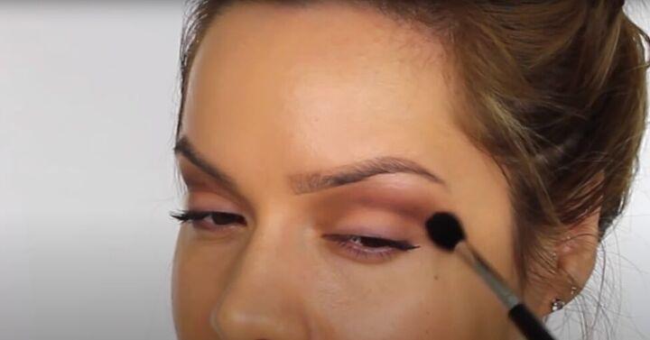 this dark sultry festive makeup look is perfect for a holiday party, Blending and buffing eyeshadow with a brush