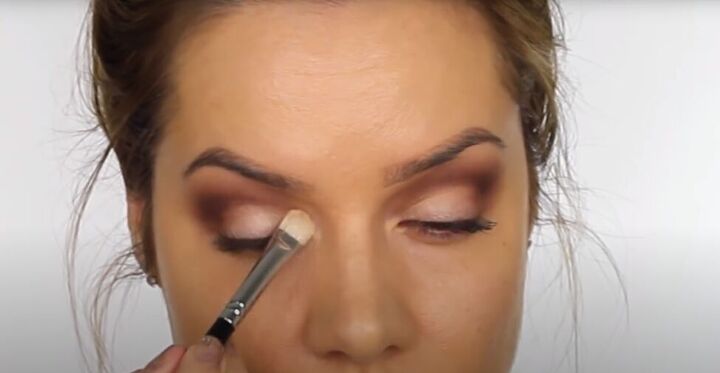 this dark sultry festive makeup look is perfect for a holiday party, Applying a cream eyeshadow to the mobile lid