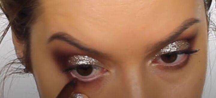 this dark sultry festive makeup look is perfect for a holiday party, Applying eyeliner to the waterline