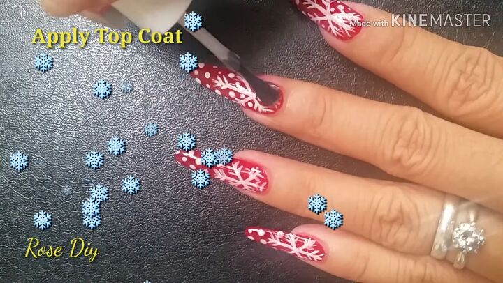 ready for christmas here s how to do cute red nails with snowflakes, Applying a clear top coat to the nail