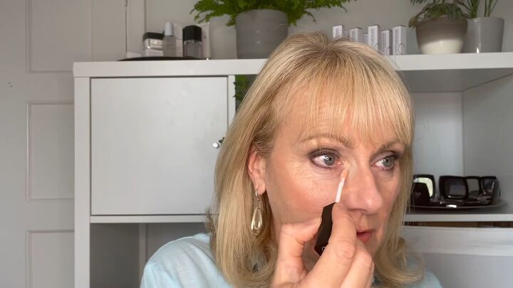 how to cover dark circles under eyes on mature skin step by step, Applying orange color corrector under eyes