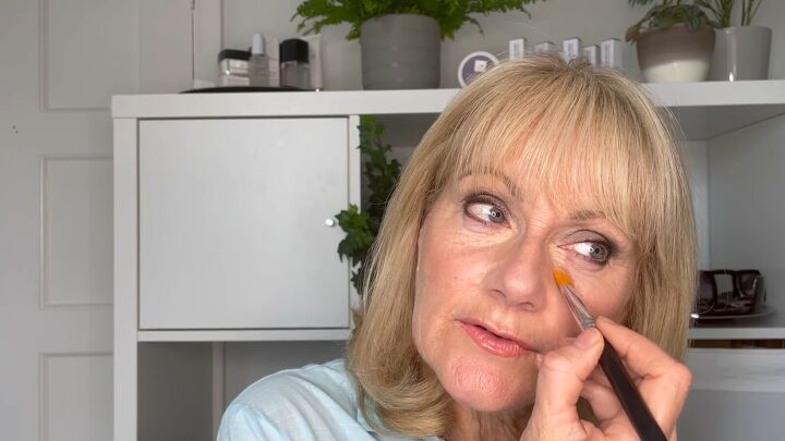 how to cover dark circles under eyes on mature skin step by step, Applying a cream based concealer under eyes