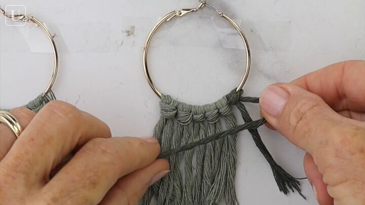 these cute diy macrame hoop earrings are super easy to make, Macrame knotting the yarn on the earrings