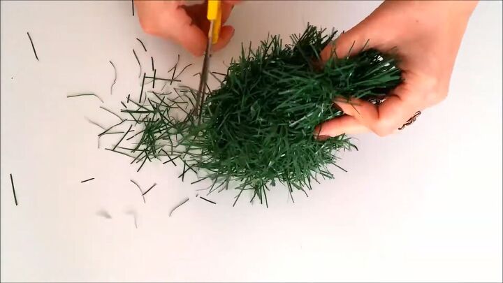 how to make cute ornament christmas tree headbands for the holidays, Trimming the Christmas garland with scissors