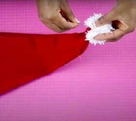 how to make a santa hat fun festive activity to do with family, Hand sewing the pompom to the top of the hat