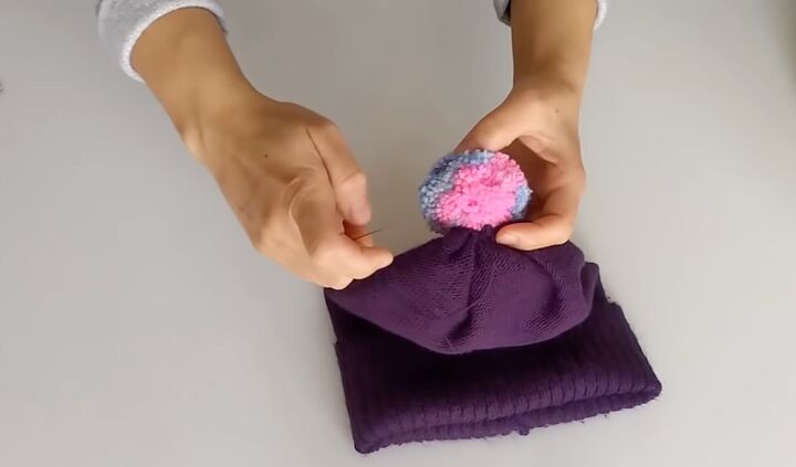 how to sew a beanie 2 ways using fleece fabric or an old sweater, Attaching the pompom to the beanie