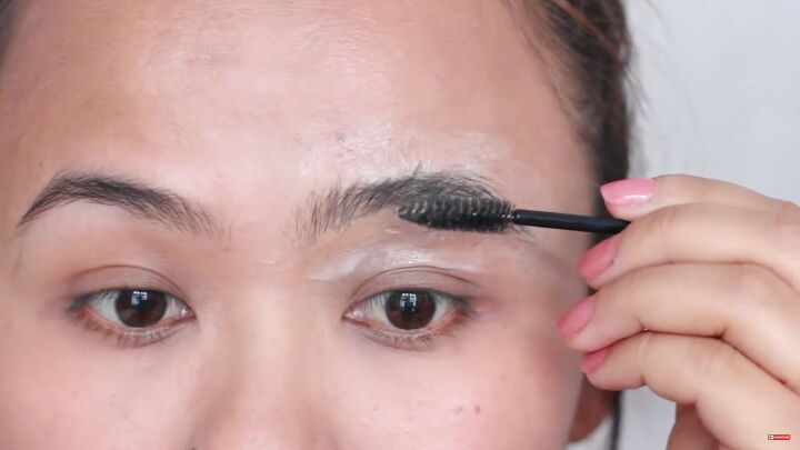 looking for painless brow grooming here s how to shave your eyebrows, Combing brow hairs upwards with a spoolie