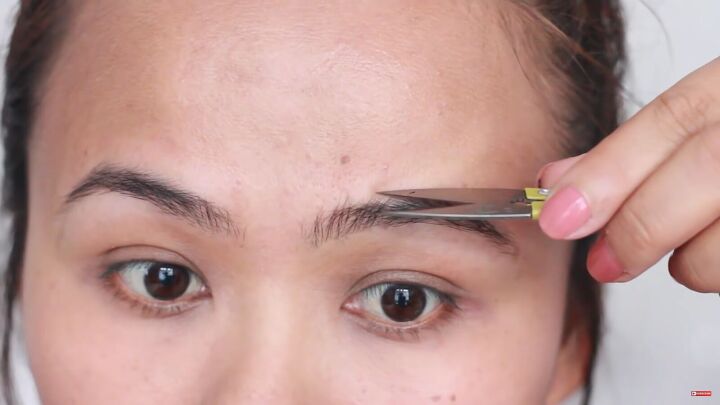 looking for painless brow grooming here s how to shave your eyebrows, Trimming eyebrows with grooming scissors