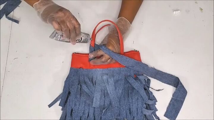 how to make a cute boho style diy fringe purse out of old jeans, Wrapping the denim strips around the strap