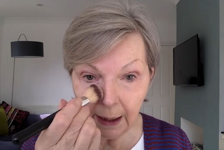 everything you need to know about foundation for an older face, Dabbing a foundation brush onto the face
