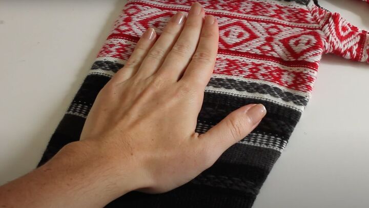 how to make a diy blanket poncho sweater mittens for winter, Placing a hand on the sweater sleeve