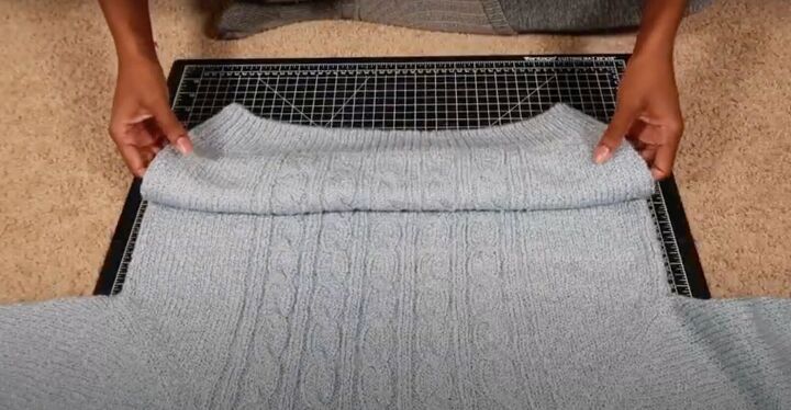 how to easily make a cute diy cropped sweater in 3 simple steps, Folding the sweater up ready to crop it