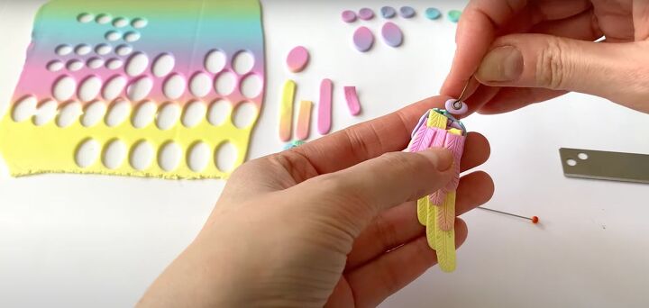 how to make polymer clay wing earrings in angelic rainbow colors, Pressing the eye needle into the clay