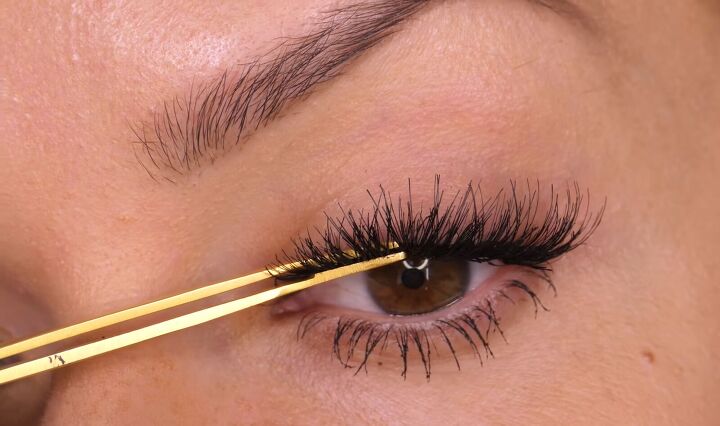 how to trim false lashes that are too long apply them like a pro, Pinching the lashes together with tweezers