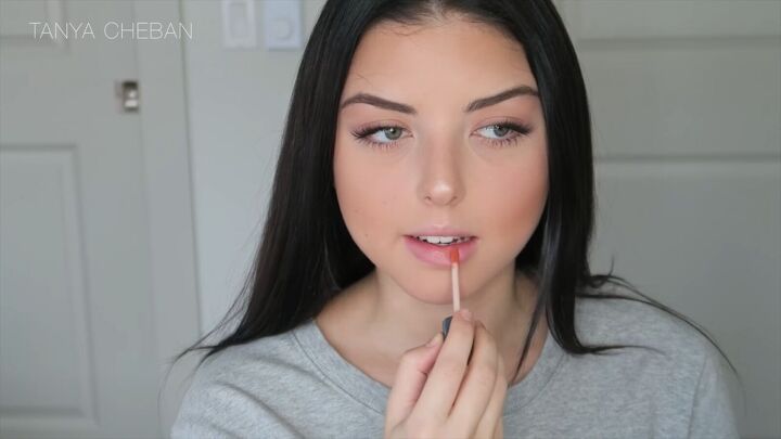 how to hide under eye dark circles with makeup in 3 simple steps, Applying lip gloss to lips