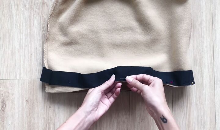 how to make a diy chanel inspired suit out of a long hoodie, Sewing the black bias binding onto the skirt hem